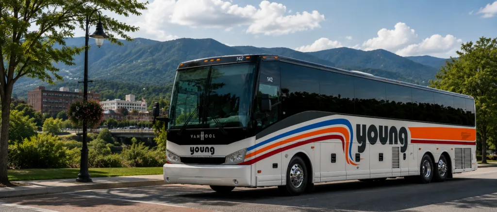 Young Transportation motorcoach parked near a mountain town on a sunny day